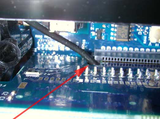 A picture of the how the antenna cable routes through the small opening that is designed to the left drive and fan assembly slot.